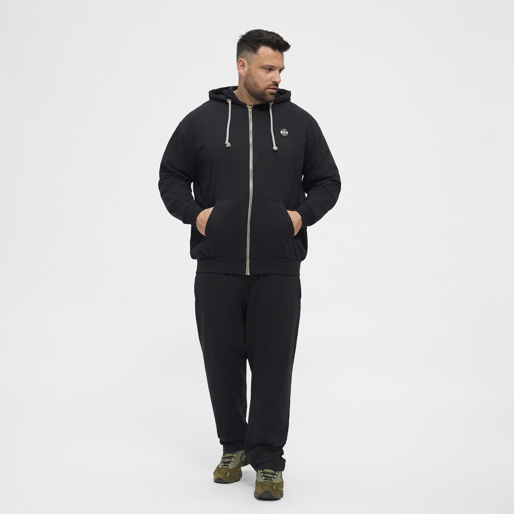 Mężczyzna w jednolicie kolorostycznym zestawie spodnie i bluza