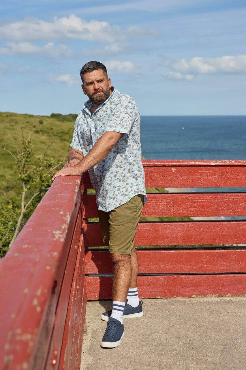 Mężczyzna w wakacyjnej koszuli nad morzem